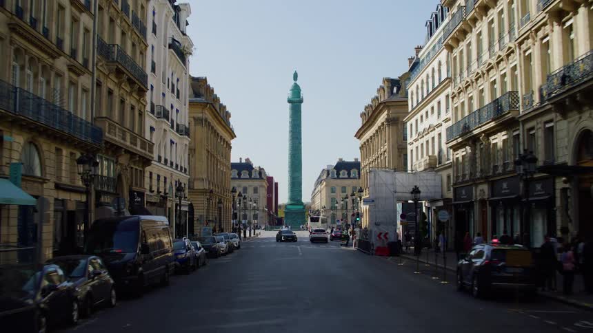 A tall monument stands at the end of a busy street
