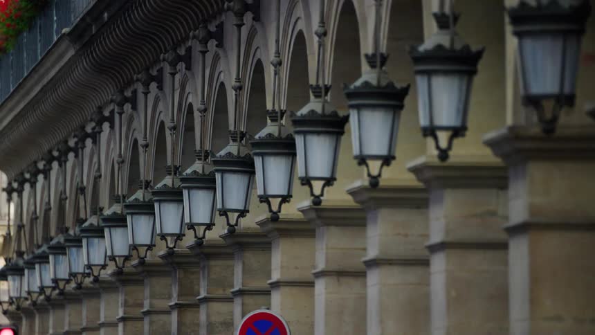 The side of the building is lined with hanging lamps