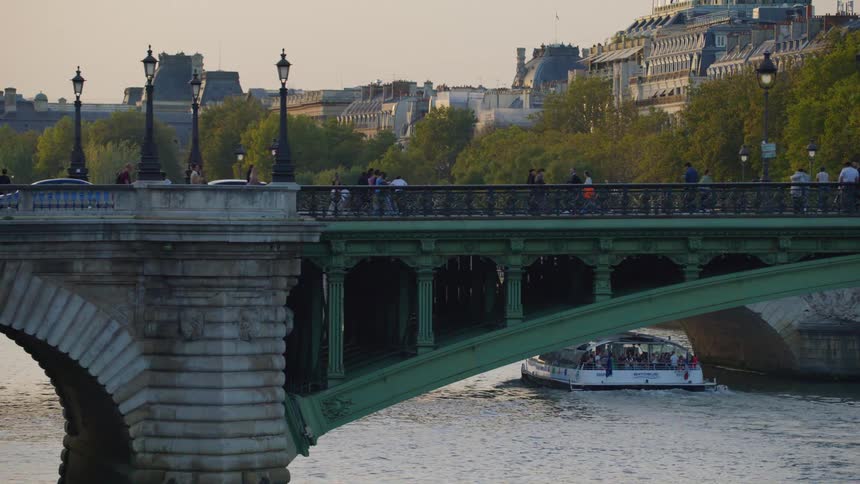 Panorama of a bridge with traffic of people and vehicles on a lake canal with tourist boats in the city