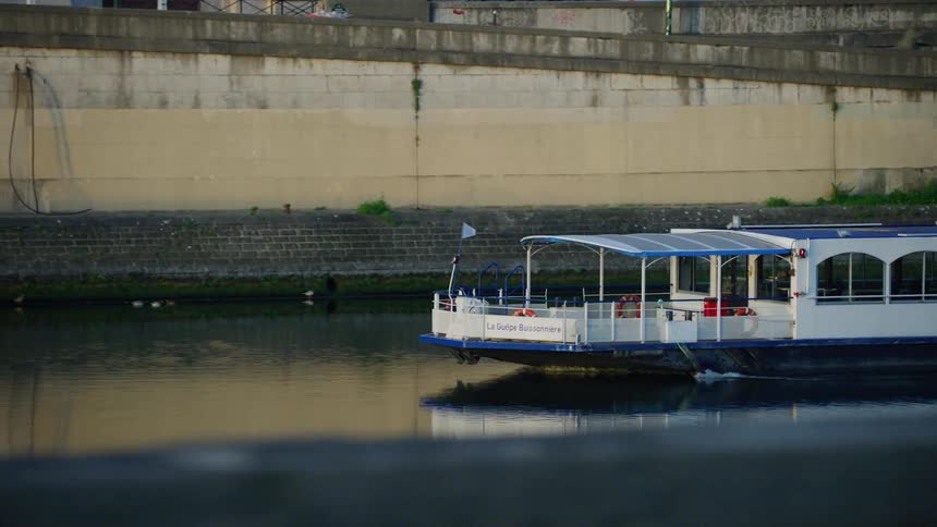 Tourist boat traveling on a canal on one side through the city