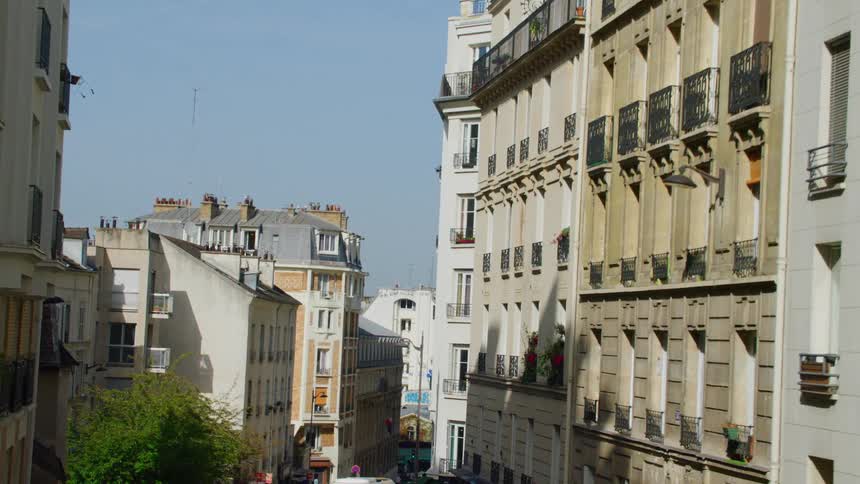 An aerial view of a street with several buildings on the side and somewhat old architecture