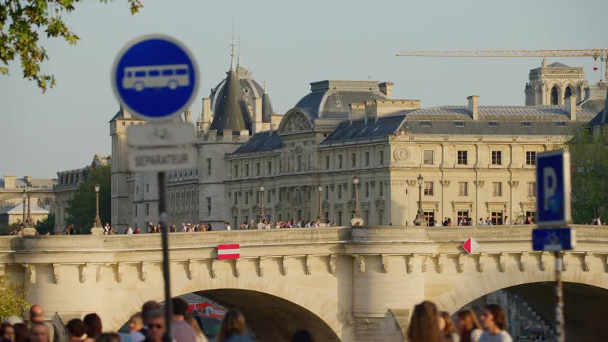 Cathedral in the middle of a metropolis next to a busy bridge with pedestrians