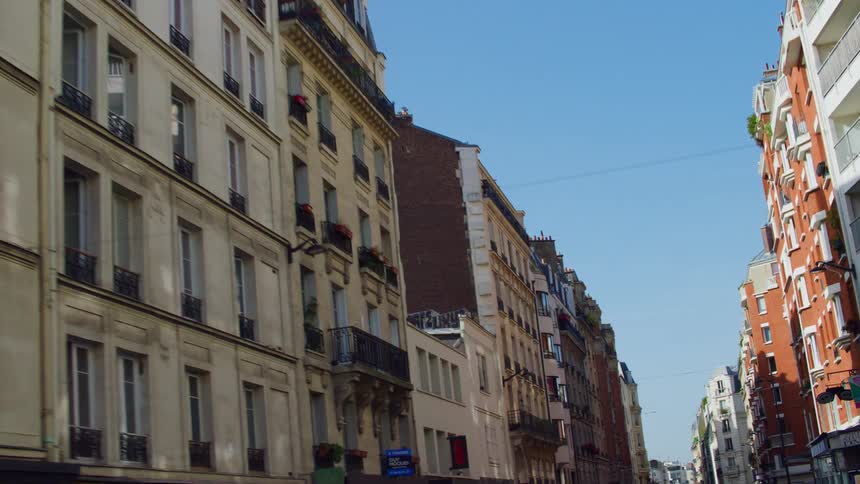 Street of a city with residential buildings on a cloudless blue sky day