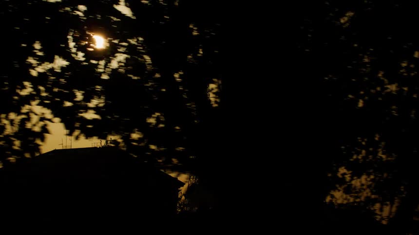 A silhouette of the eiffel tower on a day when the sun is very orange in the sky