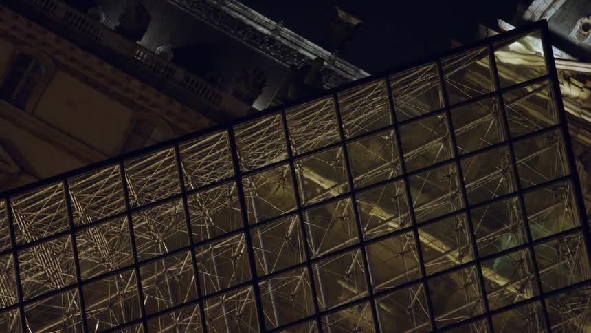 Louvre museum exterior architecture in glass at night