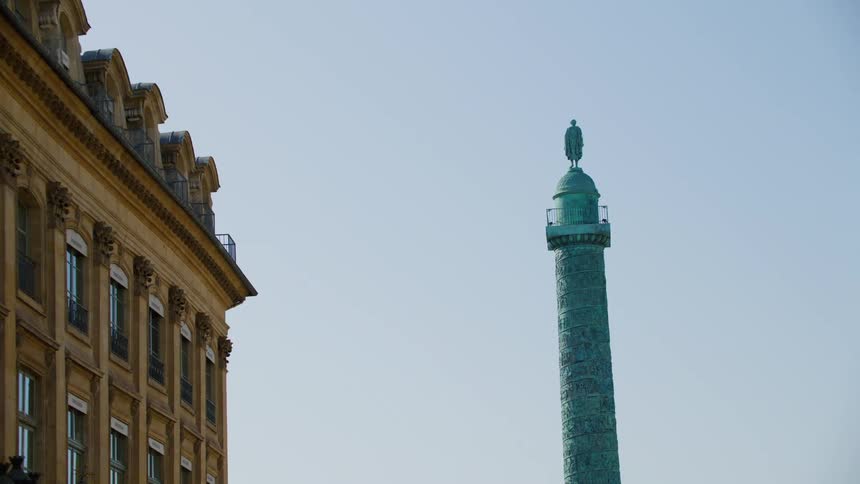 A monument with a statue at its top in a city