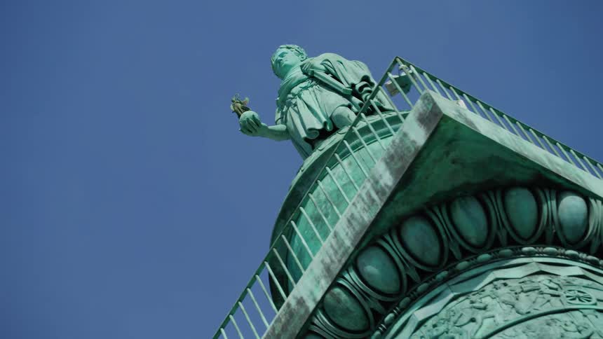 Historical and artistic pillar with the monument of a person holding a statue