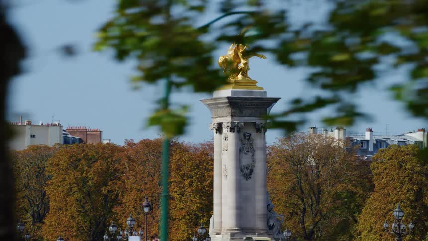 Monuments of an artistic pillar with the golden angel at the top in a square across the city