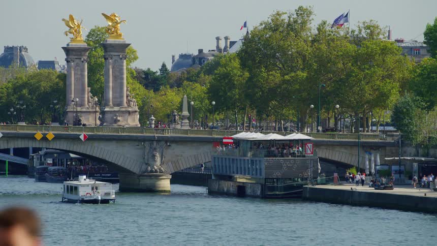 A boat and a ferry next to the famous pont alexandre iii bridge over seine river