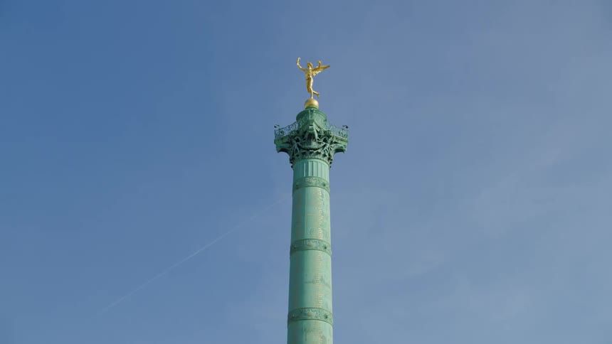 Pillar with a golden angel at the top on a monument in a square in the middle of the city