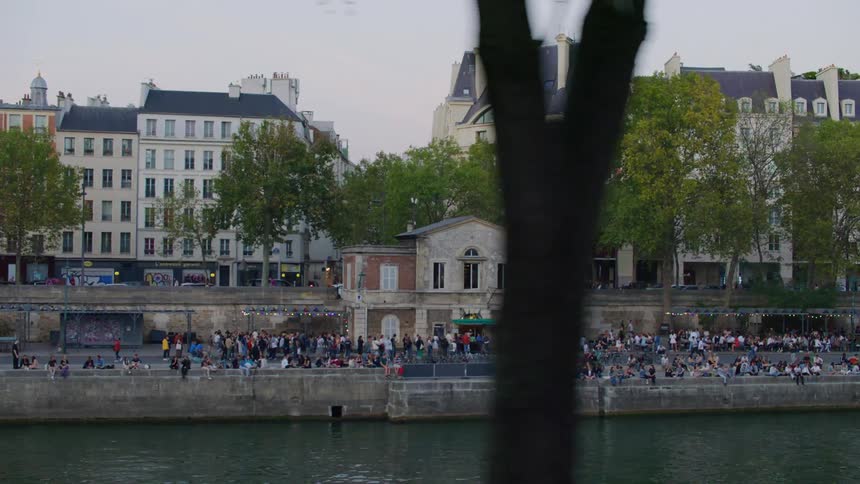People gathered in a square in the city center at sunset
