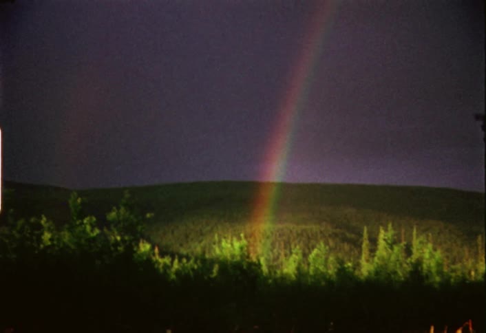 A rainbow is showing over the field ahead