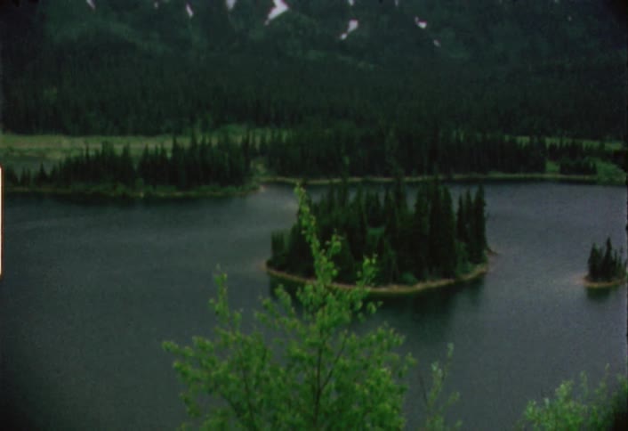The lake is calm with trees all around