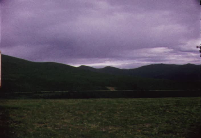 Panning view of green mountains on a very cloudy day