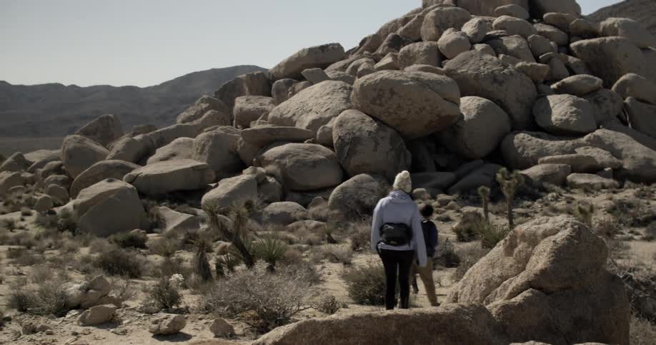 Three people walking a trail in a very rocky setting