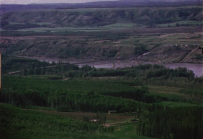 Green grass and hills with a river flowing through them