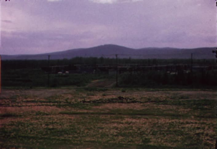 Shaky view of a field with mountains in the background on a cloudy day