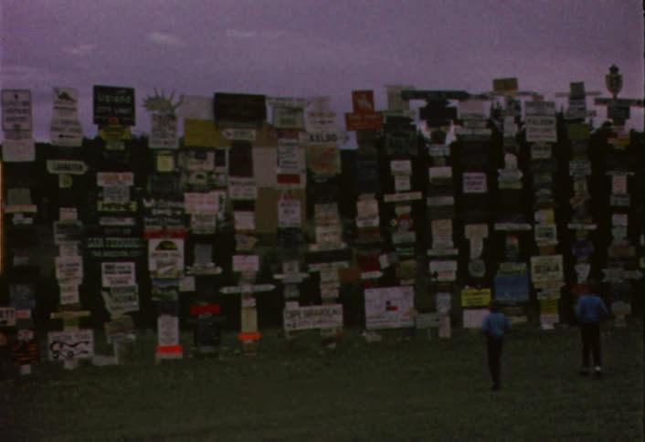 Posts covered with signs stand in a rural area