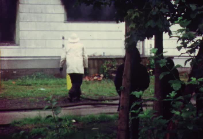 A firefighter kneels in front of a child dressed as a fireman