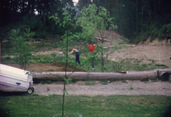 Two people are digging in a field ahead