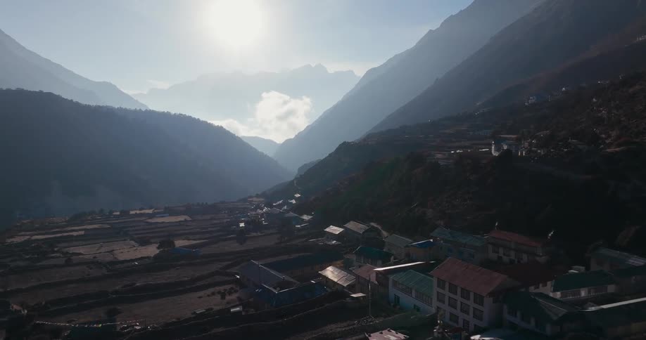 Panorama of a village built in the middle of mountains in a natural environment on a blue sky day with solar reflection