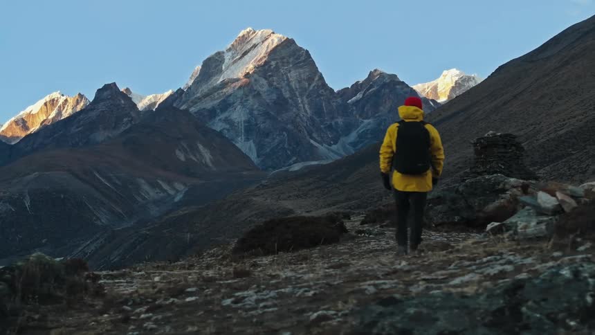 Person hiking through mountains in winter and during the day