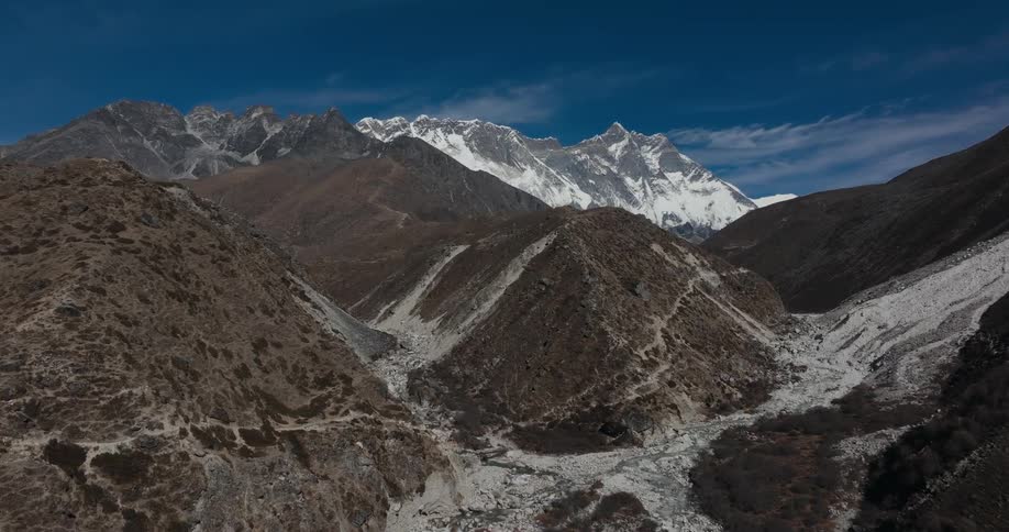 Aerial panorama of rocky mountains with a river and some with snow
