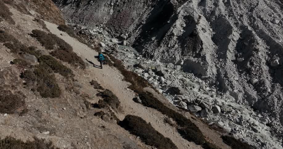 Man with big backpack walking on mountain on a sunny day