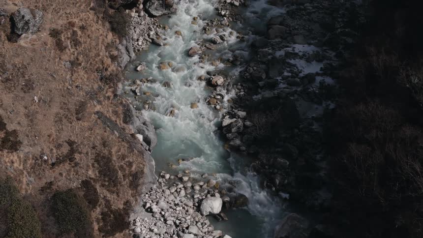 Flowing grayish river in the middle of stones and rocks