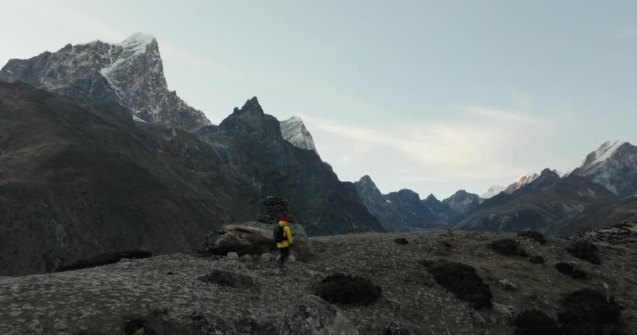 Person hiking on a hill surrounded by mountains in winter