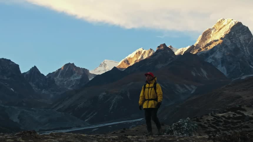 A man hiking up in the mountains on a sunny day