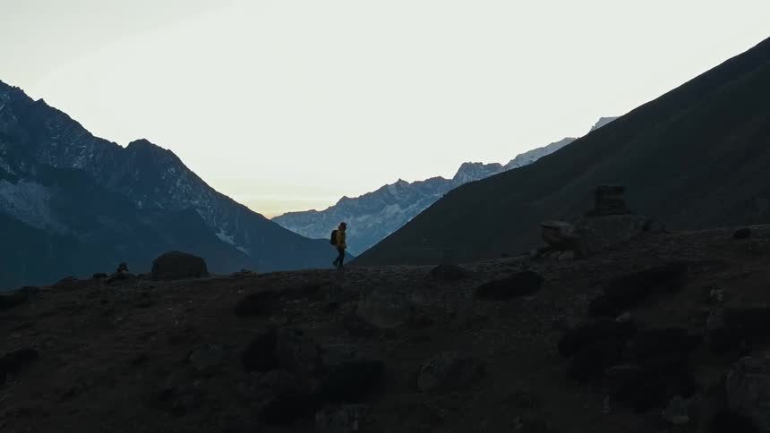 A hiker walks across a mountain ridge
