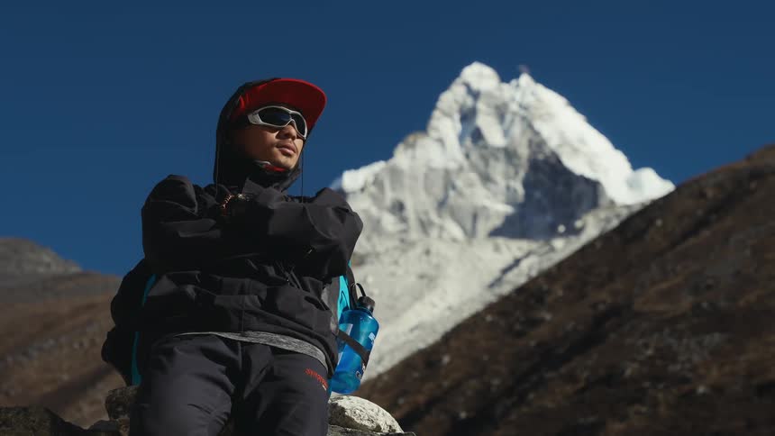 A man contemplating the landscape of frozen mountains on a sunny day