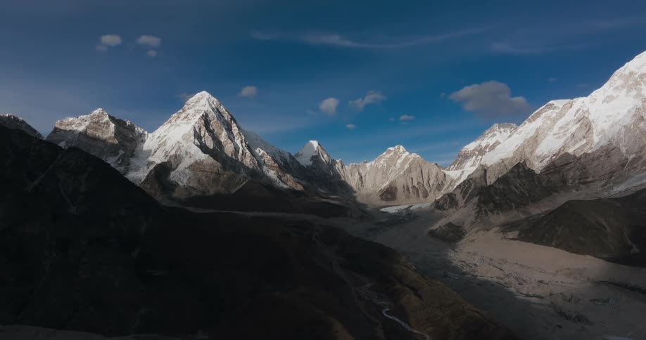 Landscape of mountain ranges covered by snow on a blue sky day with few clouds