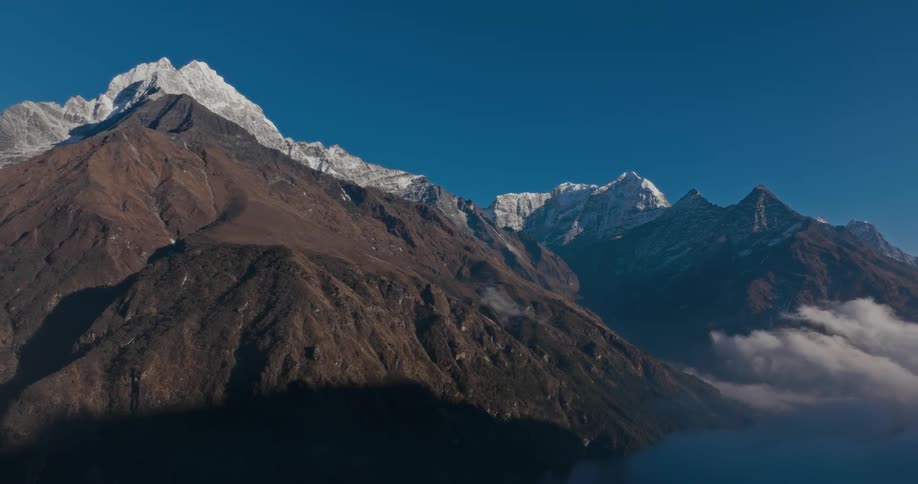 Aerial of an ice and snow mountain range on a sunny day
