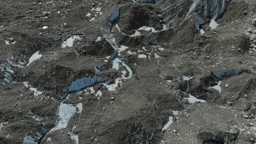 Sandy and rocky soil of a mountain with flakes of snow