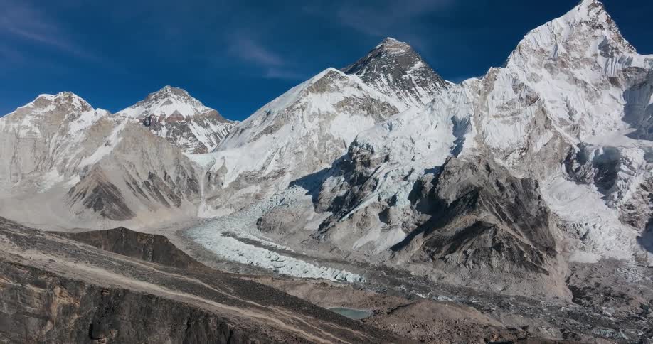Landscape of rocky mountains with cliffs covered by snow and a dark blue sky