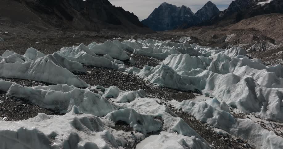 Rocky and sandy soil with snow and the natural environment surrounded by mountains