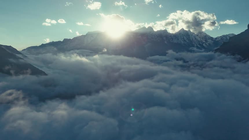 Aerial panorama of clouds in timelapse amid mountains and snowy peaks