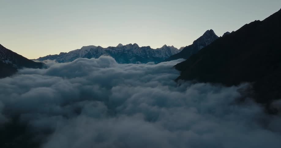 Mountains landscape above the clouds in a dark morning sky