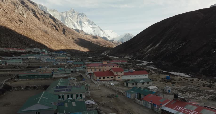 Buildings on a hill near mountains at midday