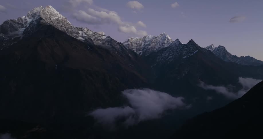 Landscape of mountains and peaks with snow in a purple morning sky