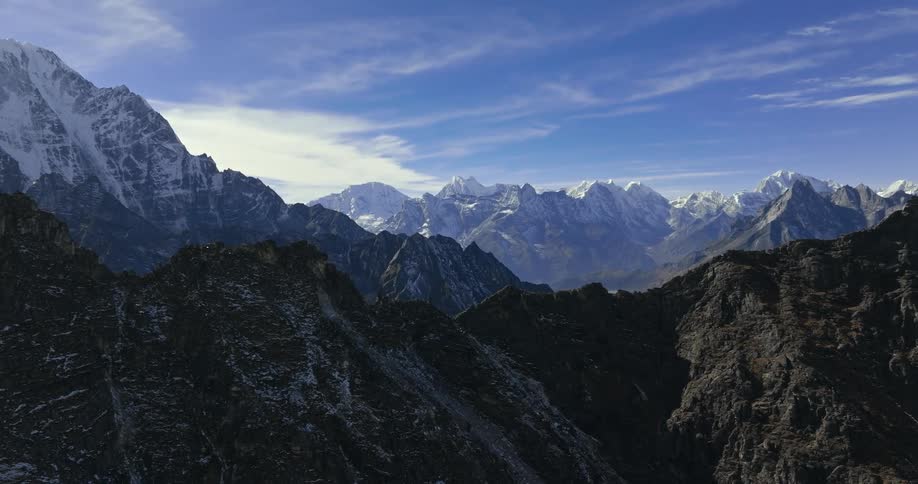 Panorama of rocky mountain ranges with cliffs and some covered by snow