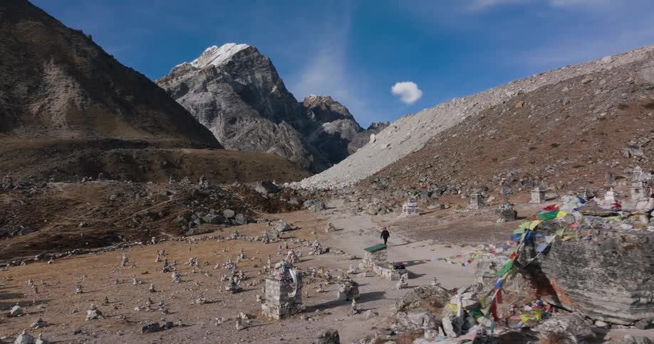 A man walks towards a cemetery in a mountain valley