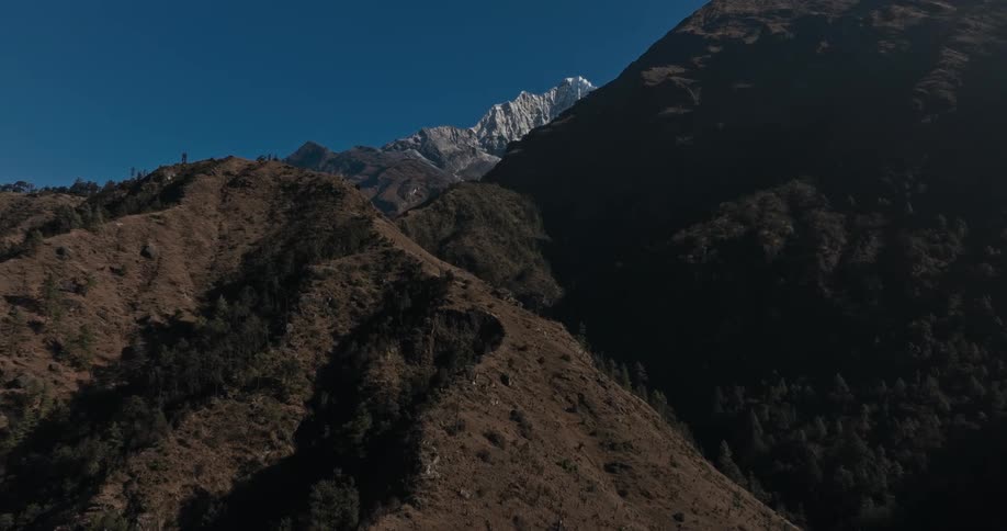 Natural landscape of hills and mountains with snowy peaks during cloudless blue sky day