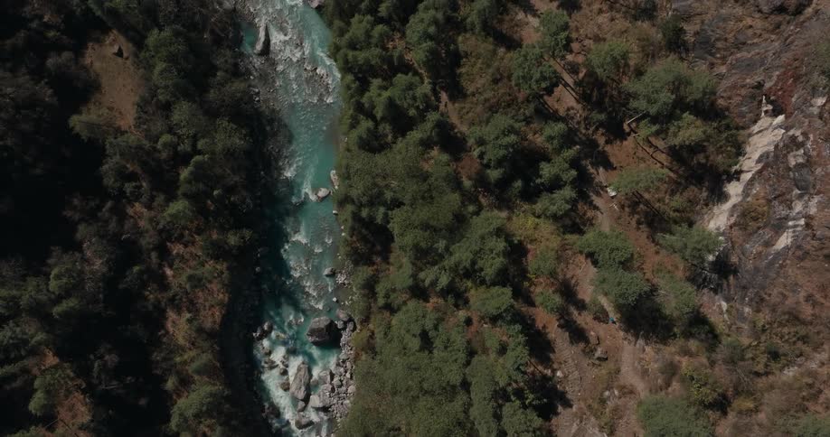 Aerial of a turquoise stream between two steep mountains