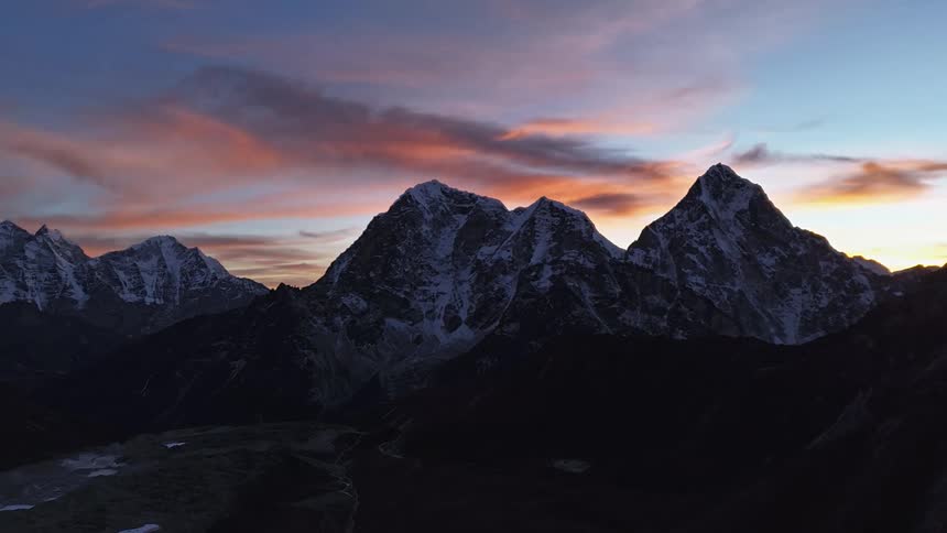 A time lapse shows clouds passing above a rocky mountain range