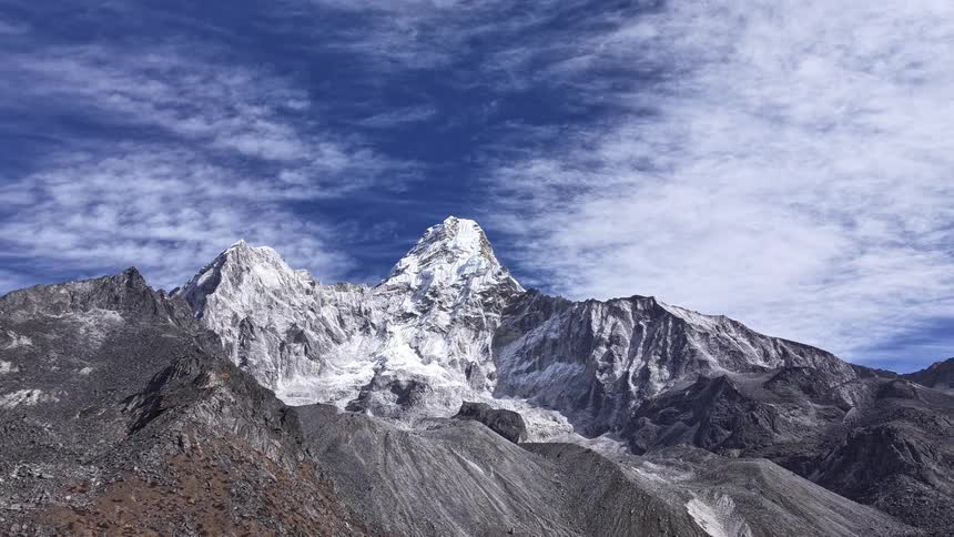 Aerial of a rocky peak with snow on a sunny day