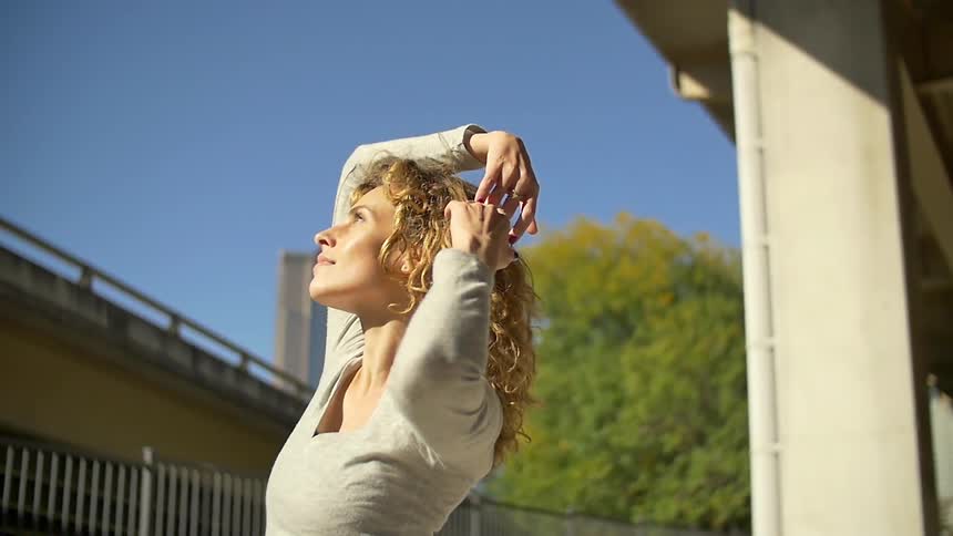A woman is dancing outside on a sunny day
