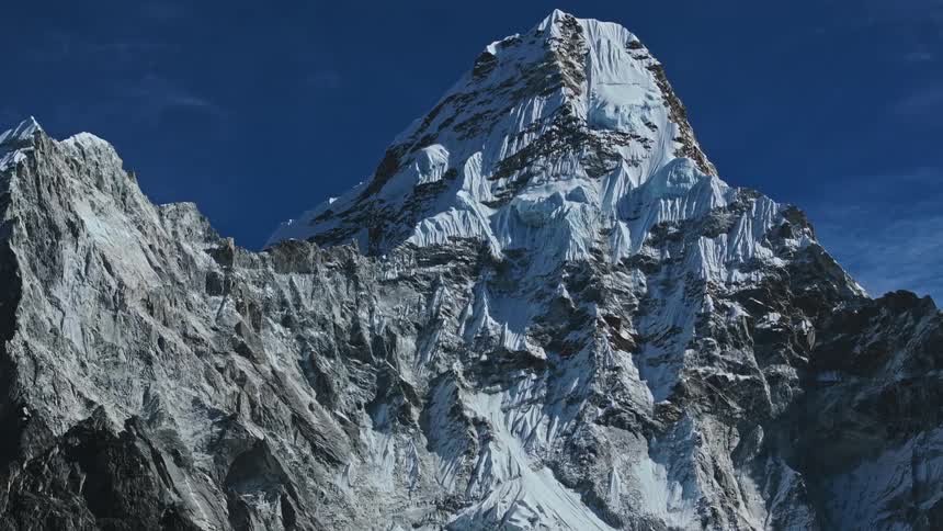 Mountain covered by snow on a blue sky day with few clouds